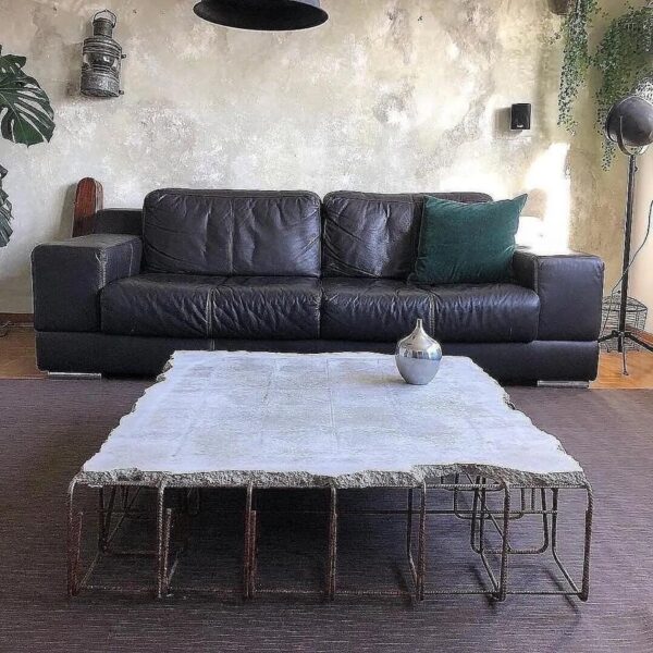 A modern center table made of steel and concrete with a minimalist design.